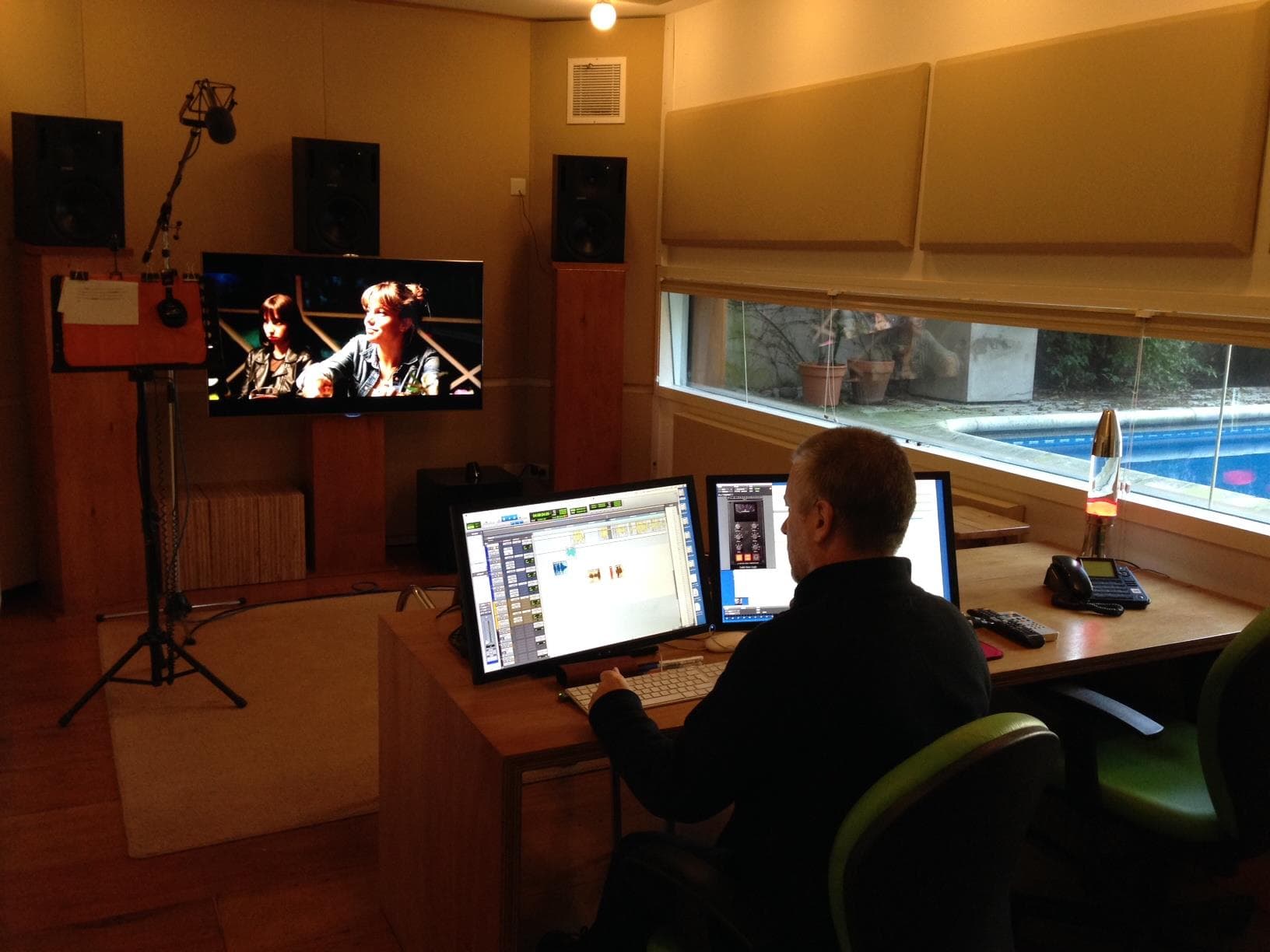 José Luis Díaz trabajando en su estudio de sonido, de espaldas a la cámara, ante los monitores y equipos de mezcla.